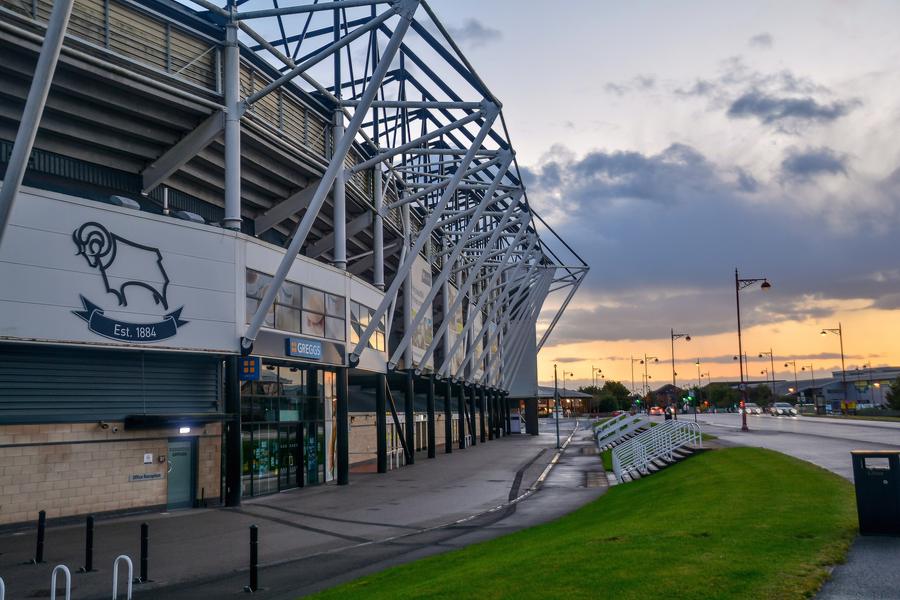 Pride Park Stadium exterior with the Derby County ram crest at dusk