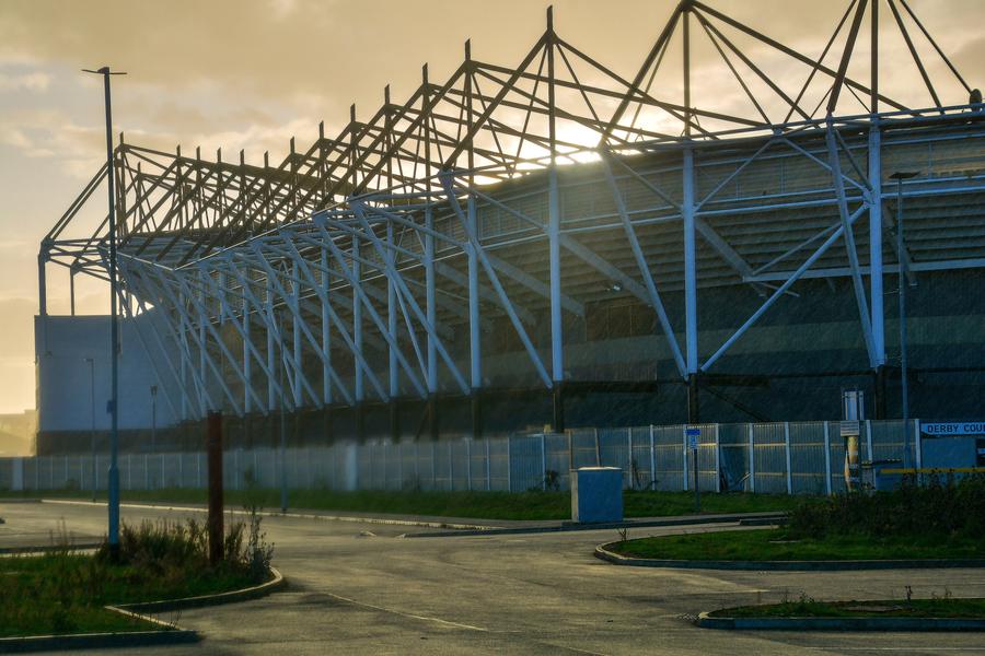 Pride Park Stadium's roof trusses silhouetted at sunset